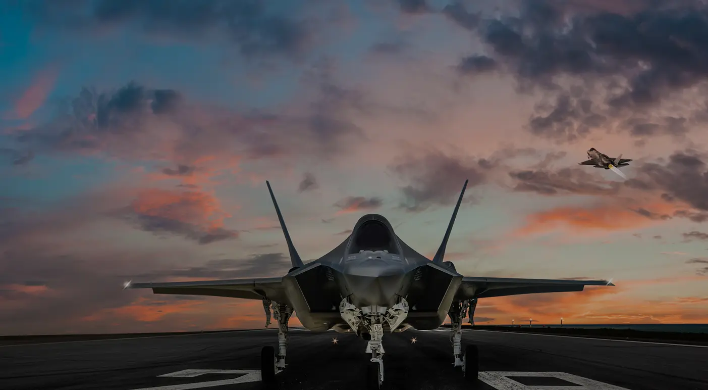 Fighter jet on a runway at sunset