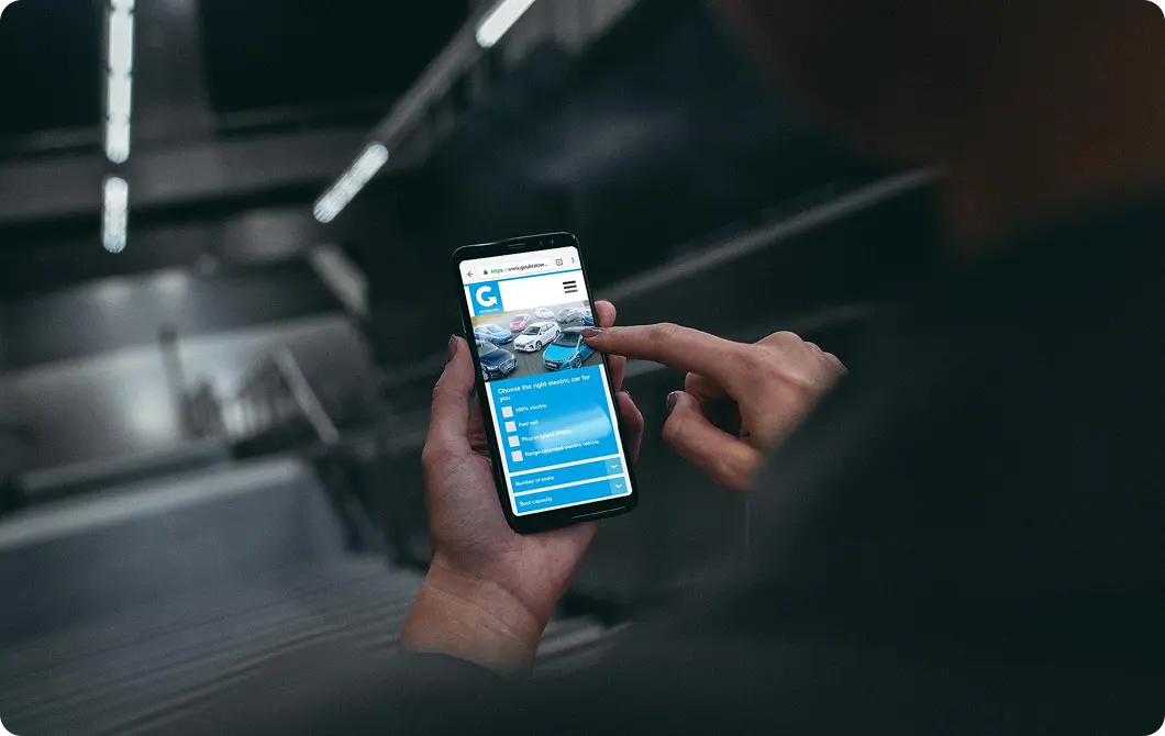 Person using a mobile website on a smartphone with a car in the background