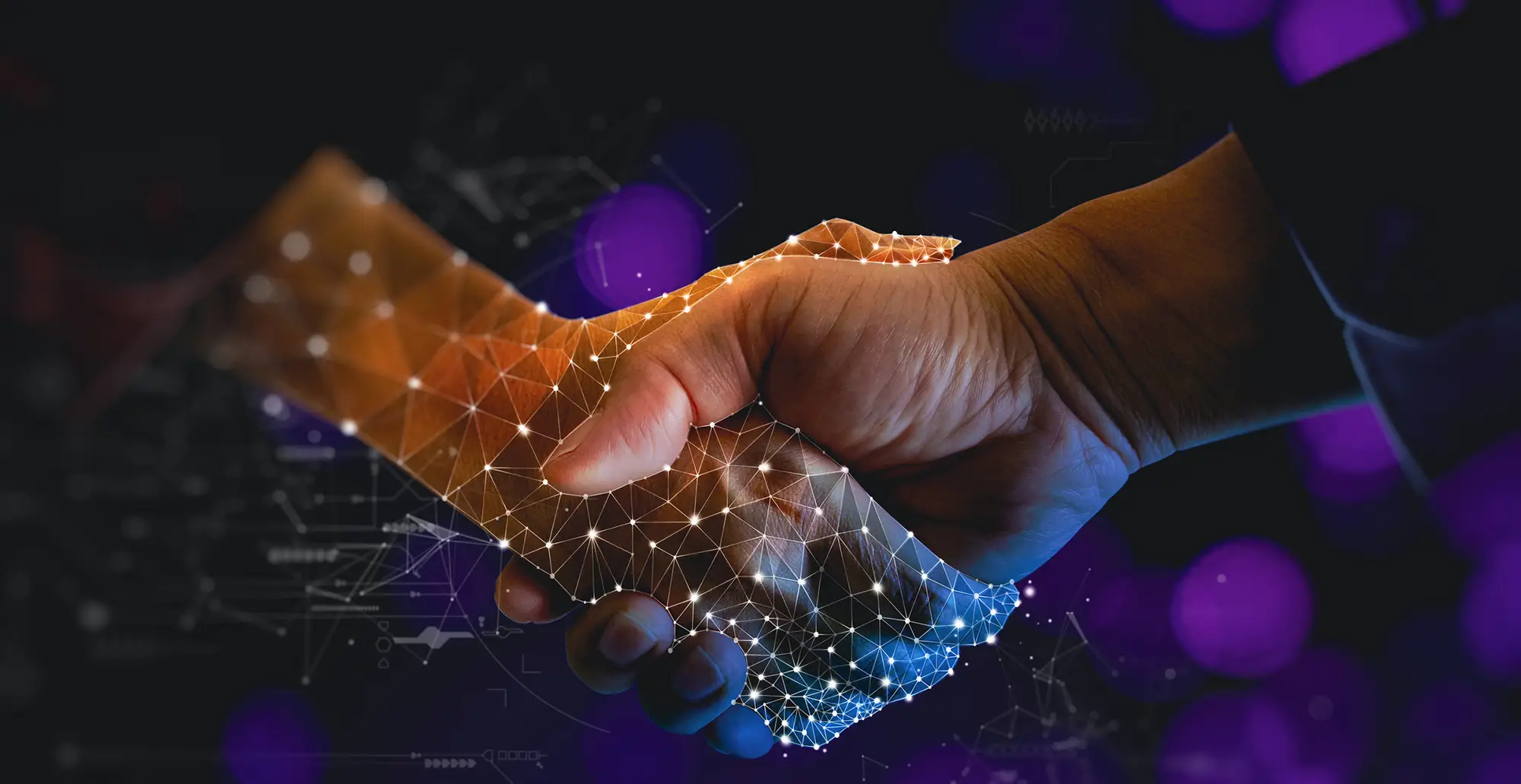 Close-up of a handshake blending a human hand with a digital wireframe, symbolising partnership, trust, and the fusion of technology with human collaboration.