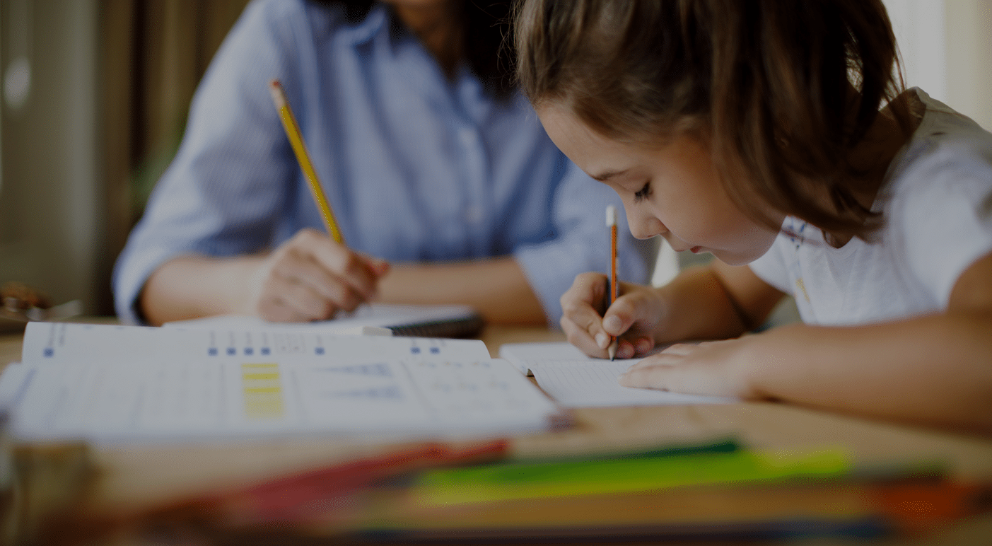 Children writing at a desk during a tutoring session